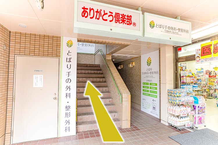 薬局入口横の階段、もしくは看板奥のエレベーターから2階にお上がりください